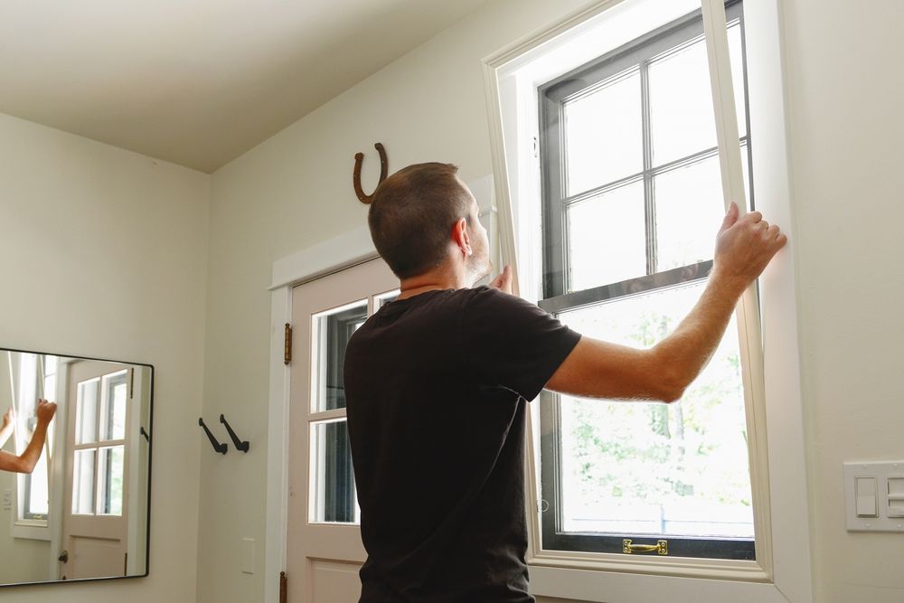 Man installing Indow window inserts. Retrofitting windows with Acoustic Grade inserts reduces noise.