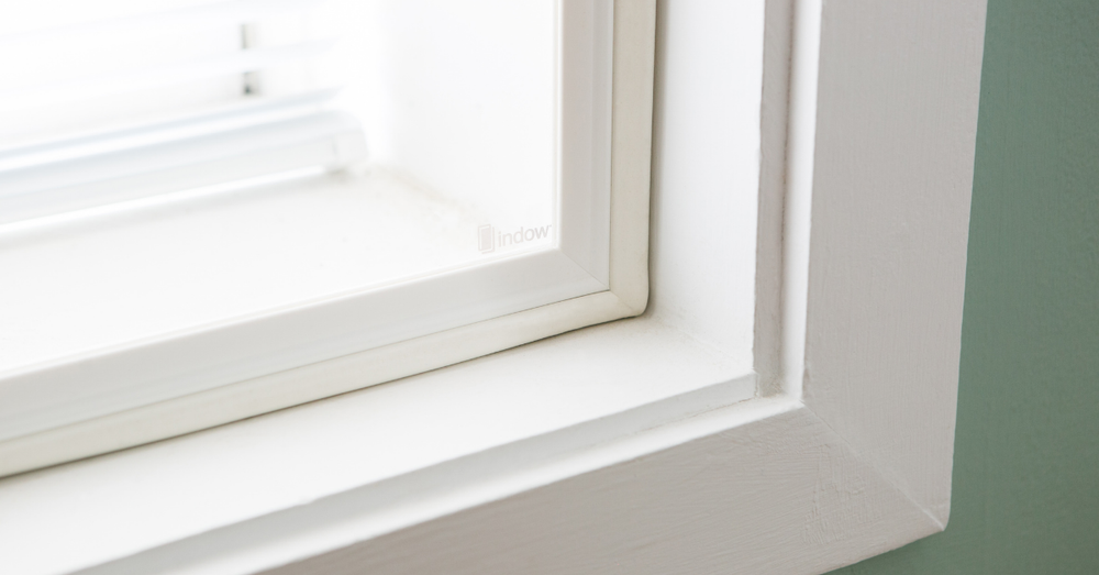 A white window frame with an Indow window insert. 